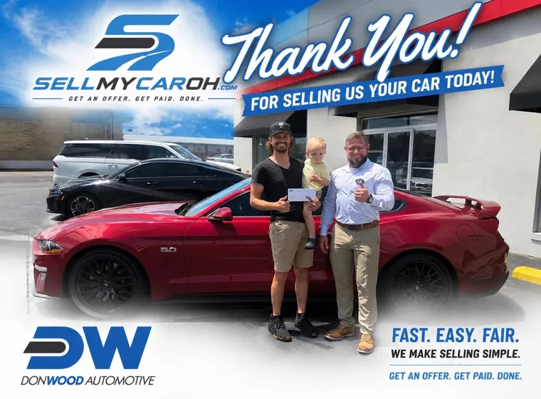 Father and son selling their red Mustang GT at the SellMyCarOH buying center